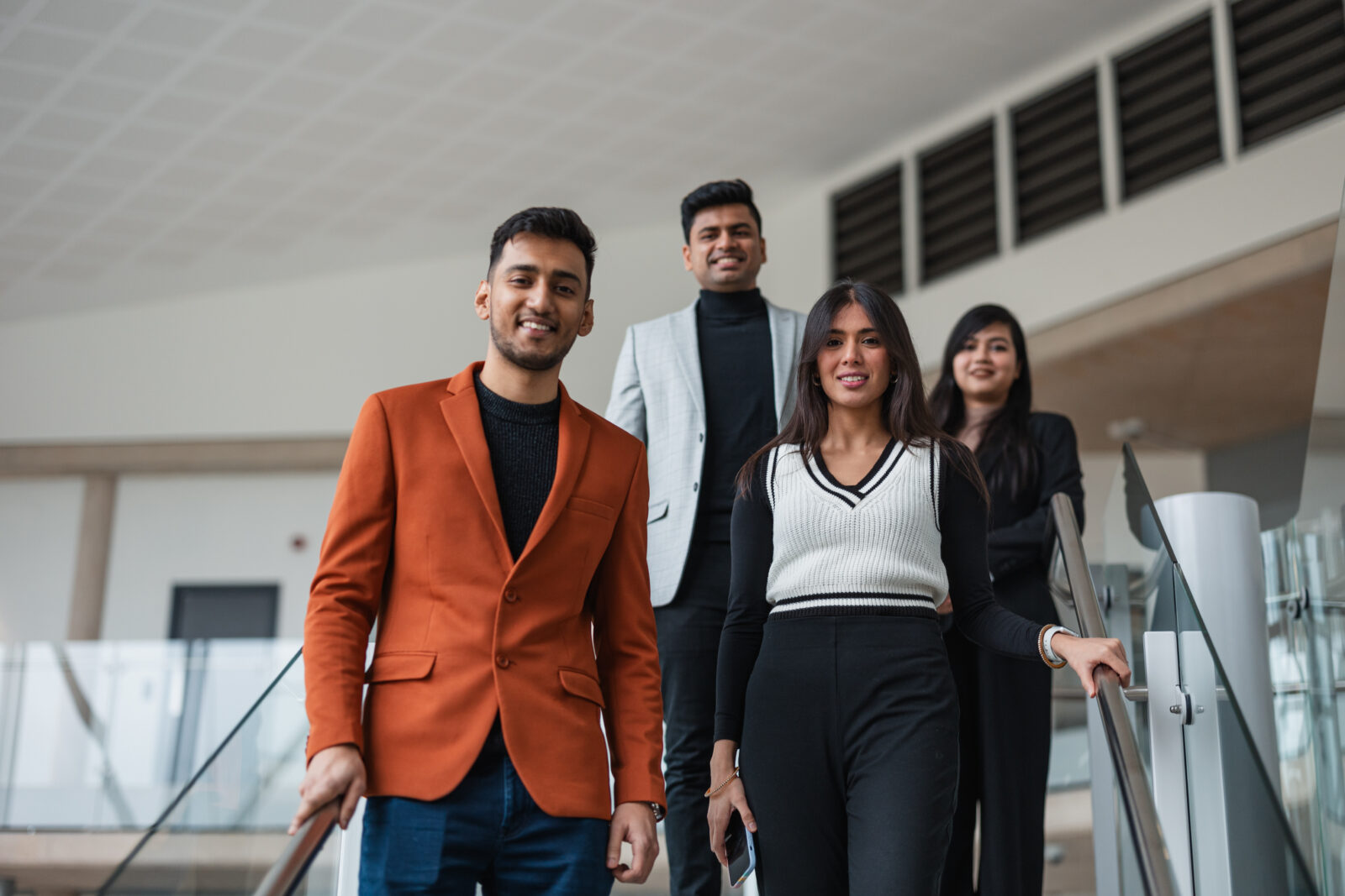 Four MBA students walking down a staircase